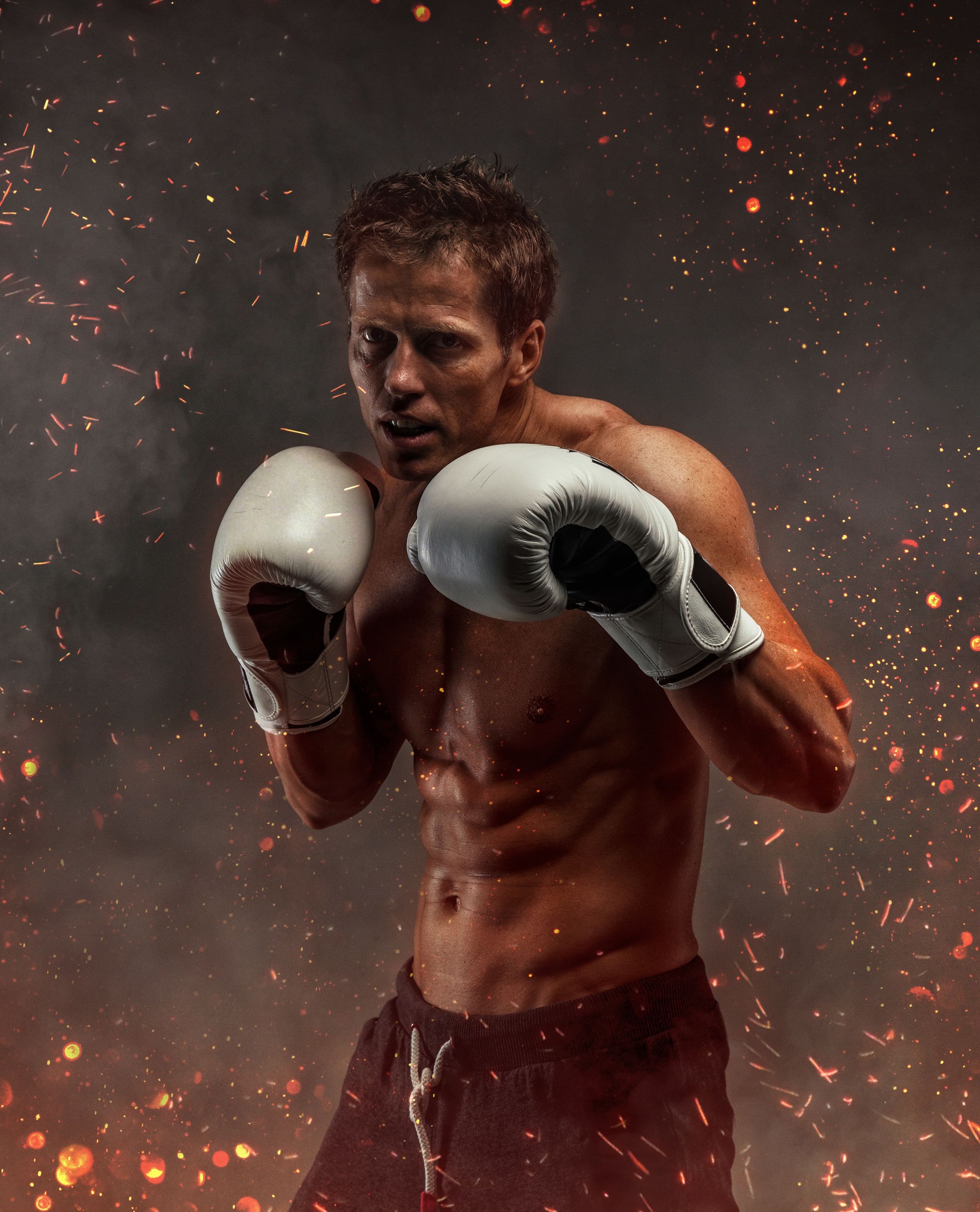 Fighter with naked torso poses in studio.